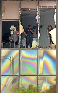 Clearwater police Officer Kurt Zamor and Lt. Nancy Miller investigate the smashed window panels. 